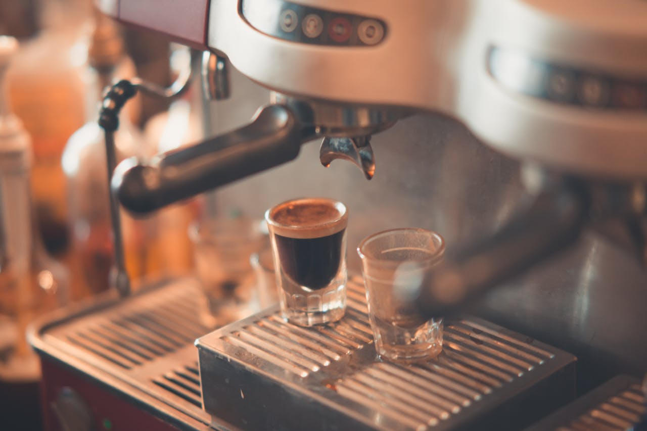 Espresso shot being brewed in modern machine with focus on fresh coffee in café setting.