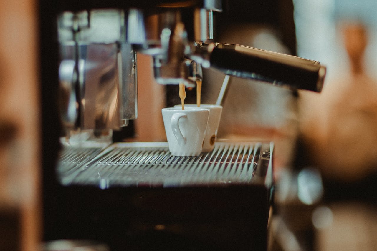 Close-up of a coffee machine pouring espresso into a cup in a cozy café setting.