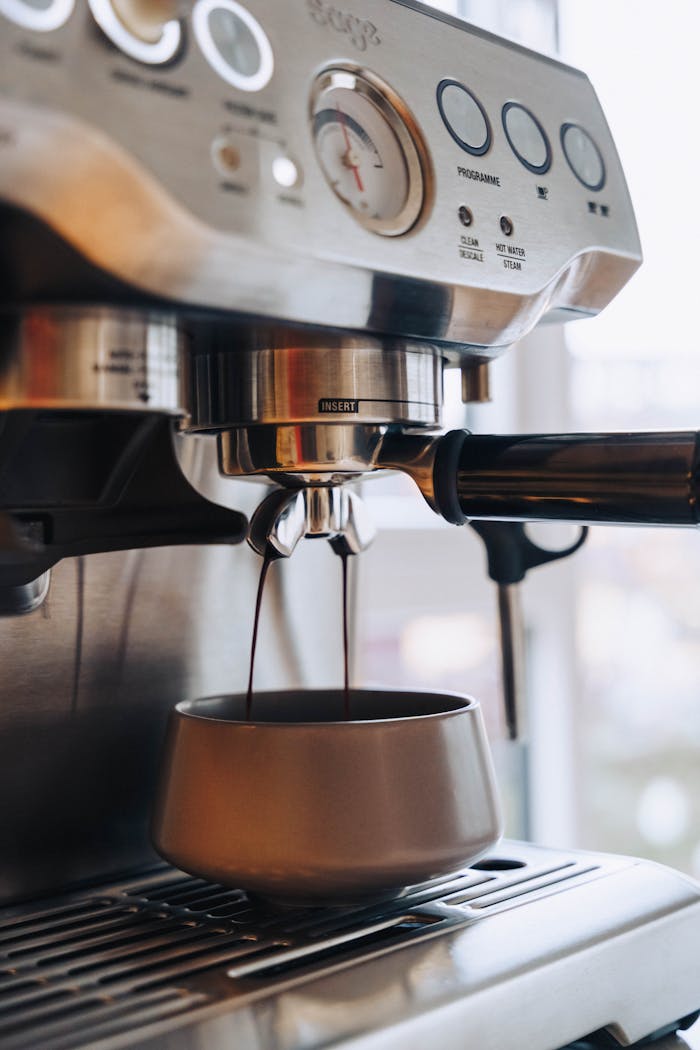 Close-up of an espresso machine brewing fresh coffee into a cup.