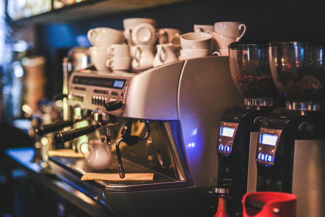 Espresso machine with cups in a dimly lit café offering a cozy ambiance.